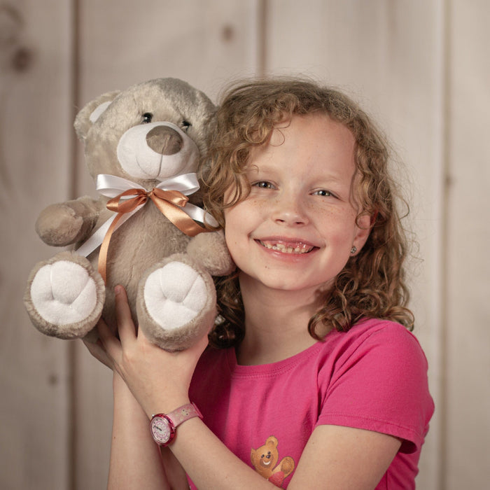 Little girl holding 10" grey teddy bear with brown and white bow
