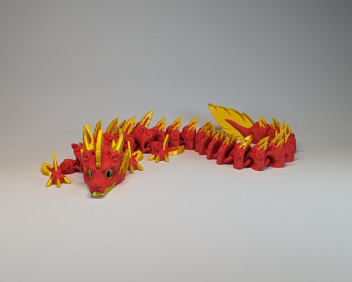 Red and yellow toy dragon on a gray background
