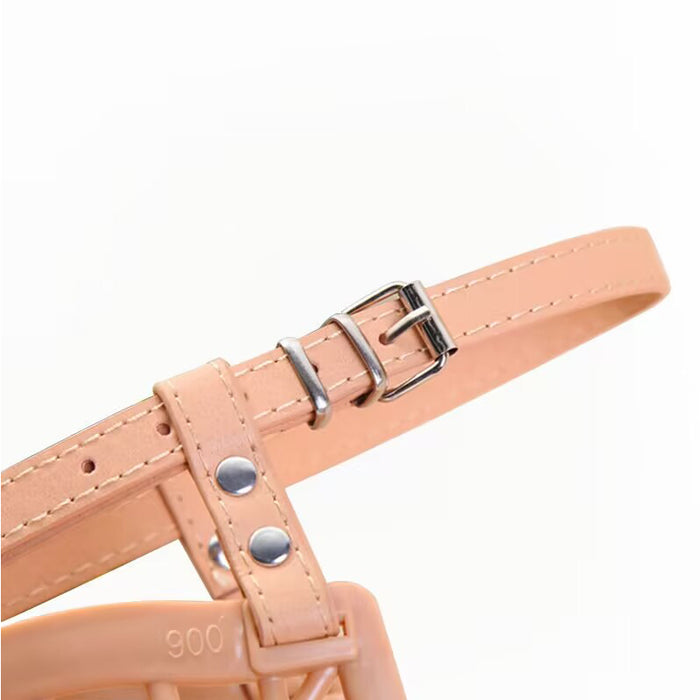 Light tan dog muzzle with an adjustable strap and silver hardware detailing.