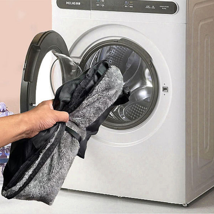 Plush travel companion pet car booster seat in grey being held next to a washing machine for easy cleaning.