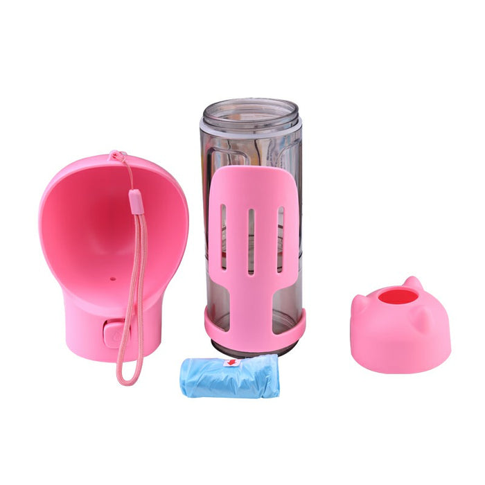 A pink portable water bottle features a clear body, a food dispenser lid, and a matching scoop with a strap.