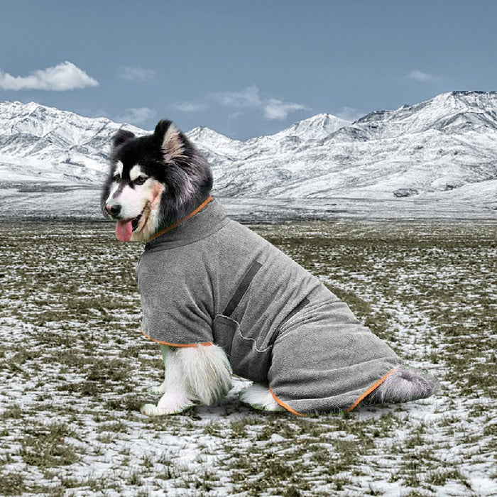 A gray microfiber dog bathrobe with orange trim is shown on a fluffy dog, set in a snowy mountain landscape.