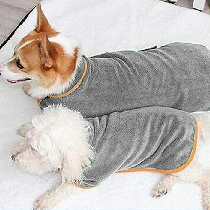 Two dogs in gray microfiber bathrobes with orange trim, lounging on a soft white surface.