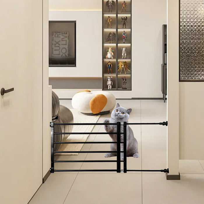 A black retractable pet safety gate is installed in a doorway, with a curious gray cat standing beside it.