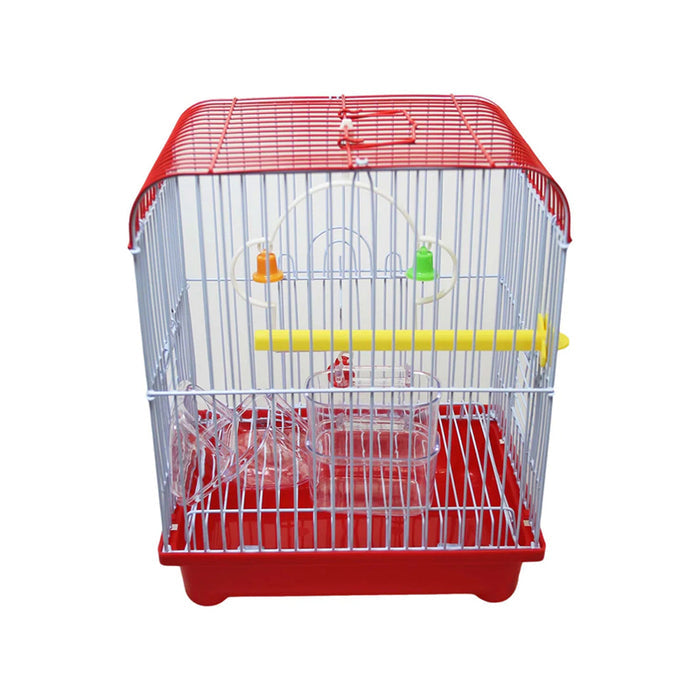 A small bird cage with a red base, silver bars, a yellow perch, and colorful hanging bells, featuring clear food and water containers.