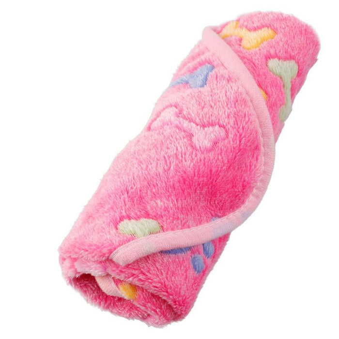 A rolled-up pink pet mat featuring colorful bone and paw print patterns, made from soft, plush material.